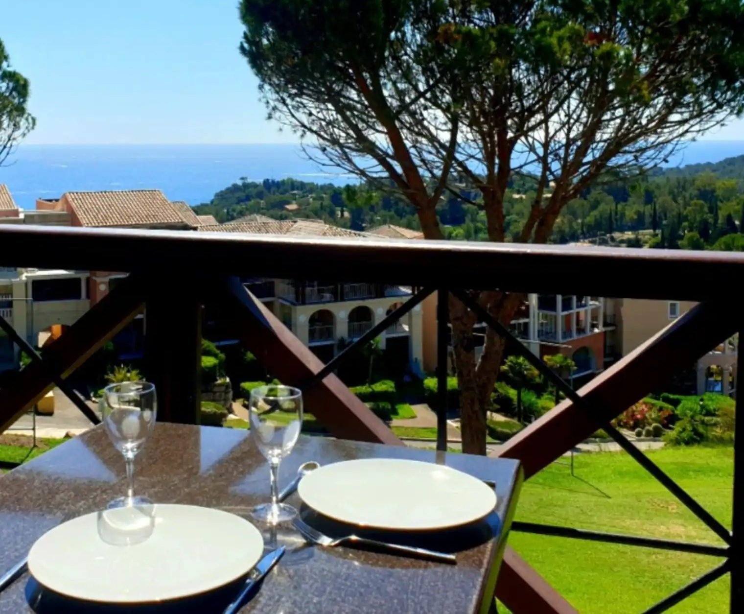 La table dressée sur la terrasse couverte du T2, face à la mer et aux pins parasols